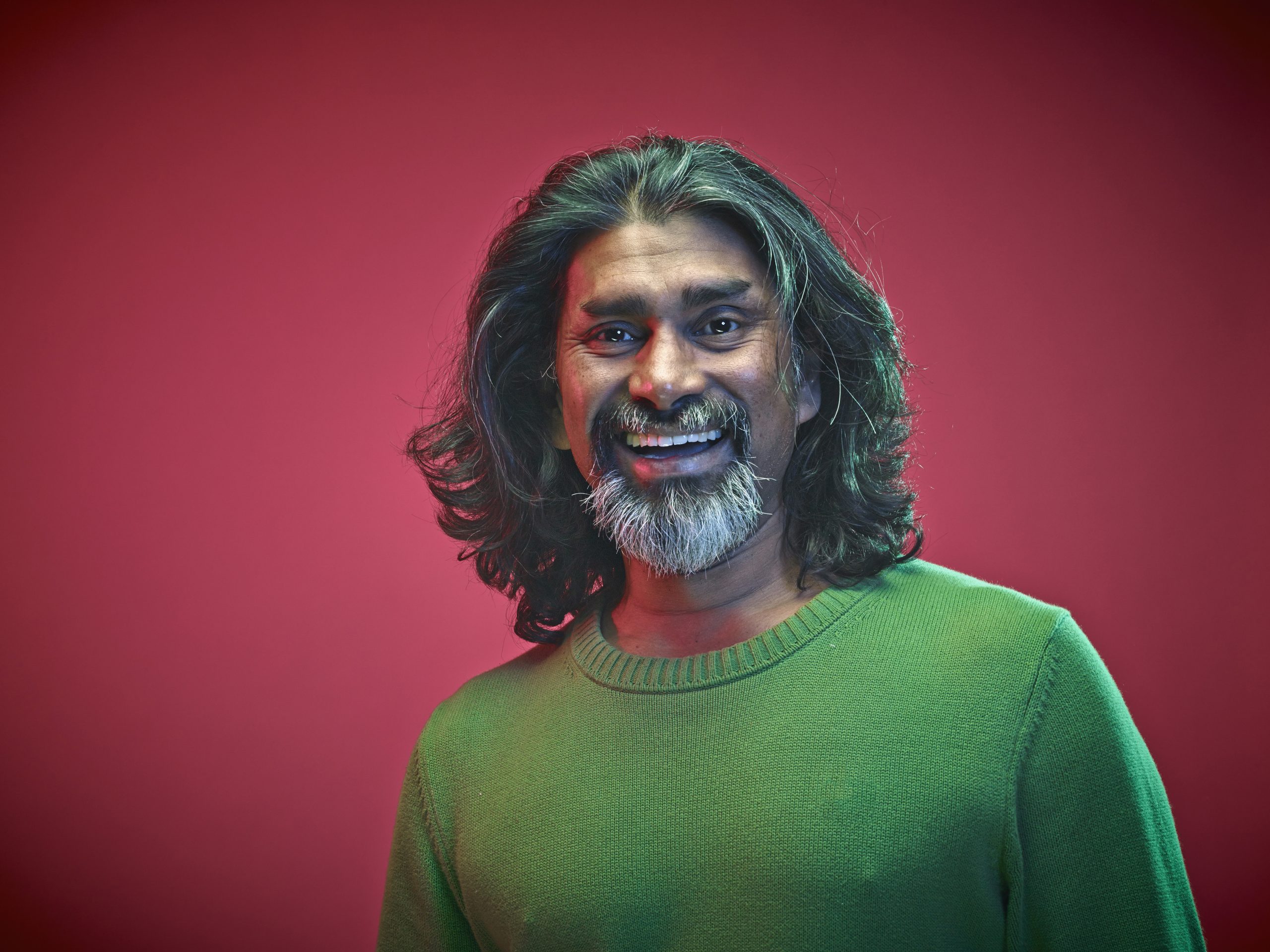 Portrait of smiling man in front of red background