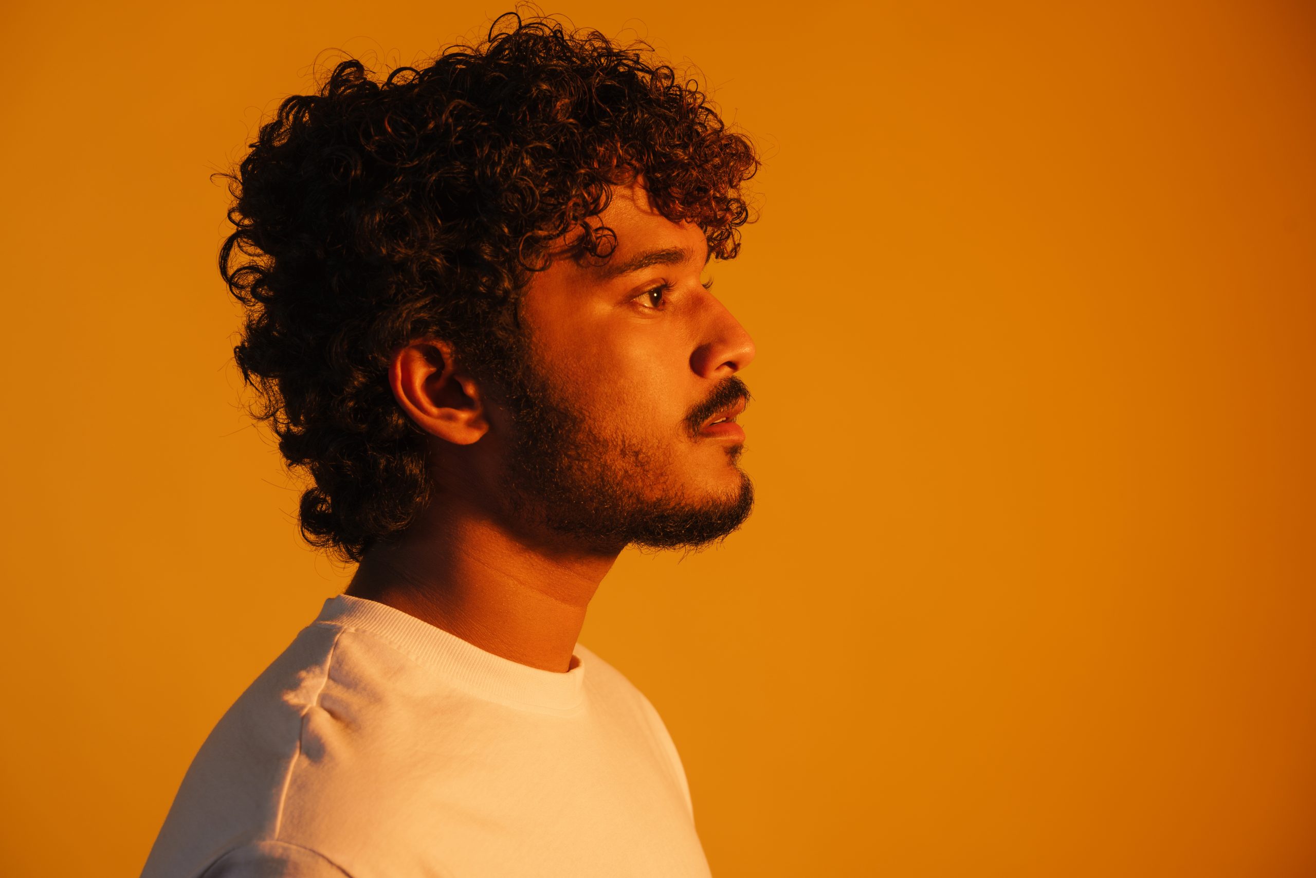 Young bearded man dressed in t-shirt posing and looking aside